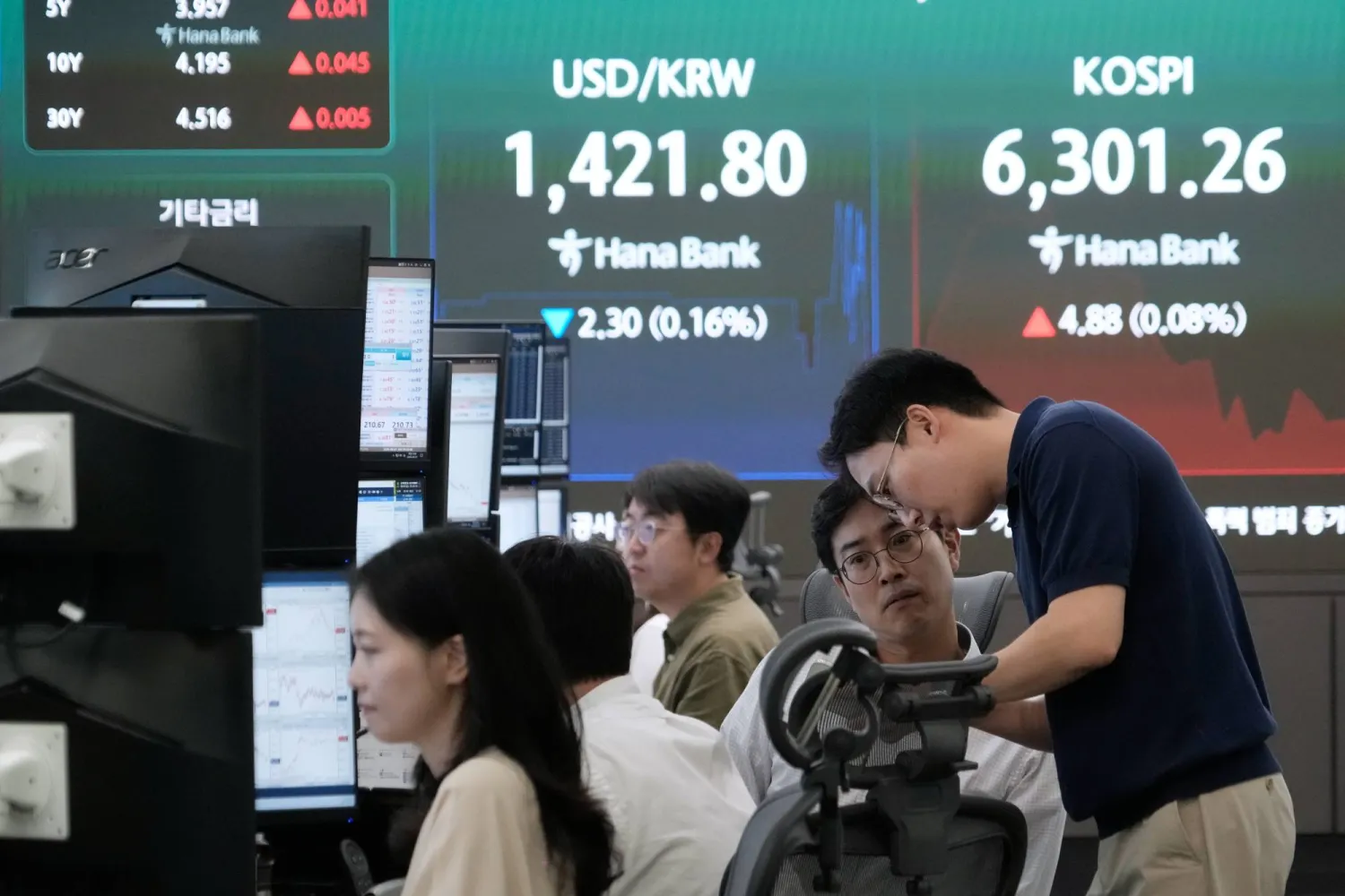 متداولو العملات يراقبون تحركات مؤشر «كوسبي» وسعر صرف الدولار مقابل الوون في غرفة تداول العملات الأجنبية ببنك «هانا» في سيول (أ.ب)