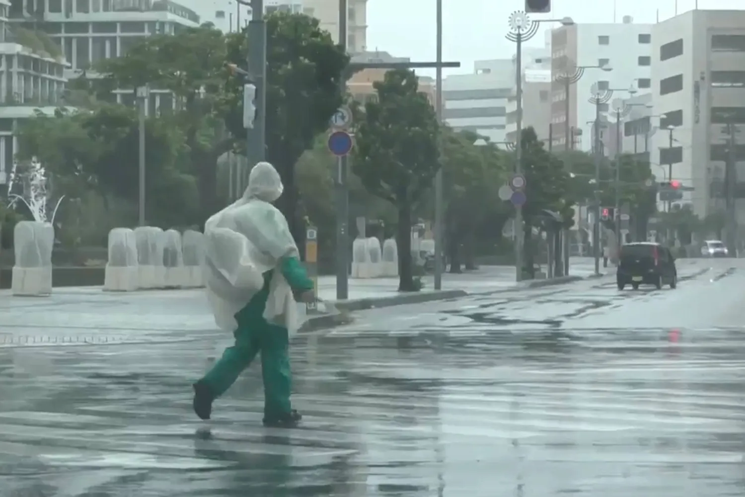  In this image made from video provided by NTV-NNN, a person walks in the rain as typhoon Dolphin approaches the city, in Naha, Japan, Friday, Aug. 7, 2026. (NTV-NNN via AP) 