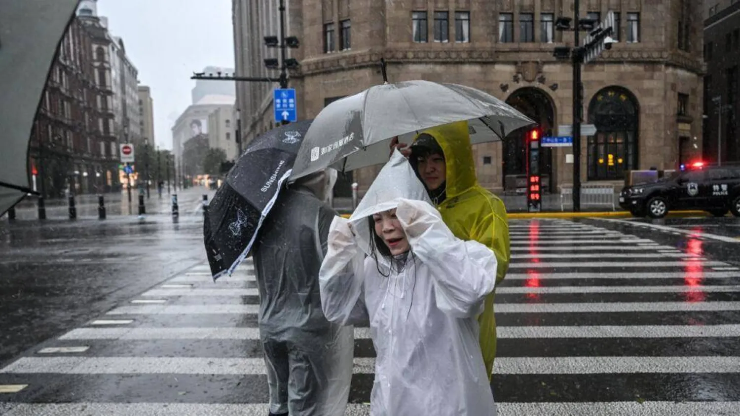 People visit the Bund in Shanghai in heavy rain, a day after Typhoon Dolphin made landfall in Shanghai, on August 10, 2026. Hector RETAMAL / AFP
