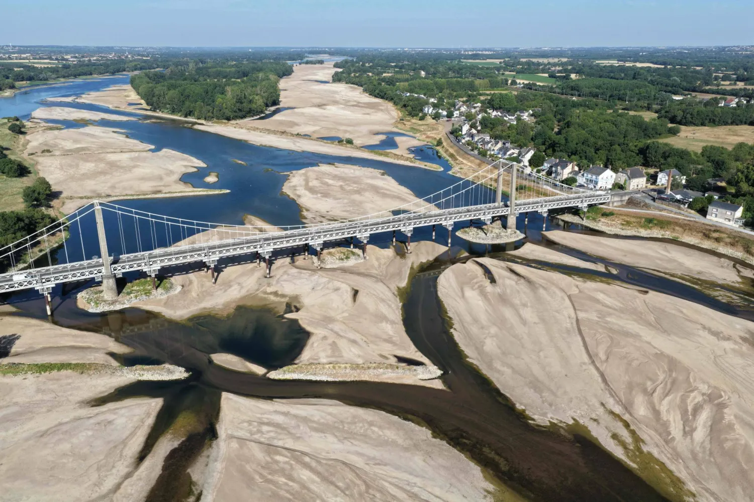 (FILES) This aerial photograph shows a bridge over the dried out Loire River bed in Loireauxence (Varades), western France, on July 10, 2026. (Photo by Damien MEYER / AFP)