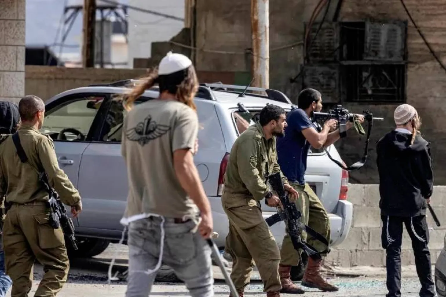 مستوطنون وجنود إسرائيليون مسلّحون في بلدة حوارة بالضفة الغربية المحتلة (أرشيفية - أ.ف.ب)