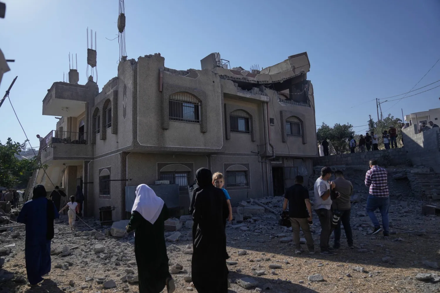 يتفقد السكان شقة الفلسطيني فاروق رمضان بعد أن هدمها الجيش الإسرائيلي في قرية تل بالضفة الغربية قرب نابلس (أ.ب)