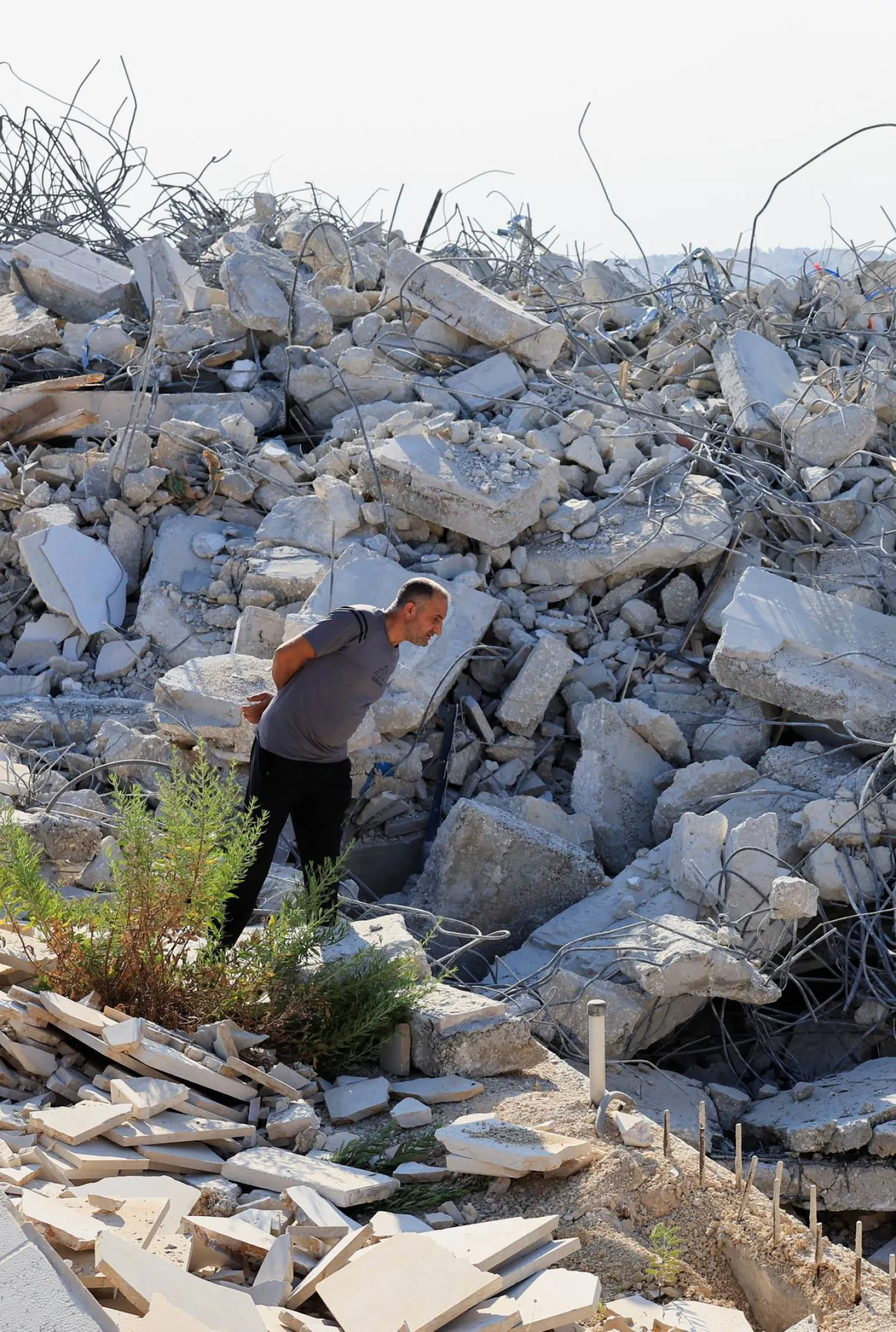 فلسطيني يتفقد الأضرار بعد أن هدمت آليات إسرائيلية مبنى فلسطينياً قرب بيت لحم في الضفة الغربية المحتلة (رويترز)