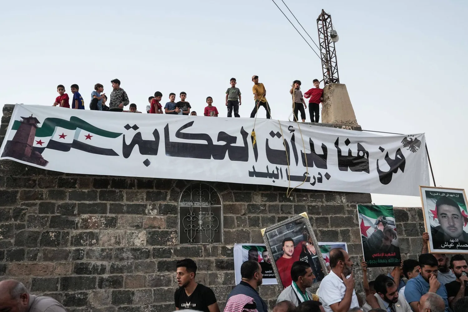 احتفال السوريين خارج المسجد العمري بدرعا الموقع الذي بدأت فيه الثورة السورية عام 2011 وذلك عقب صدور حكم قضائي سوري بإعدام عاطف نجيب المسؤول عن حملة القمع بالمدينة (د.ب.أ)