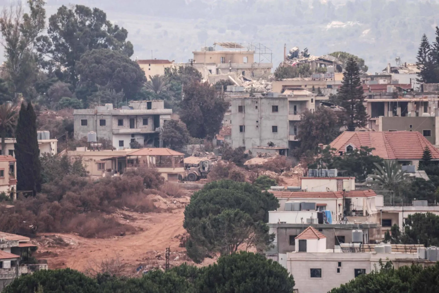 A photograph taken from the southern Lebanese village of Zawtar al-Gharbiyeh shows Israeli tanks as they maneuver in the nearby village of Zawtar al-Sharkiyeh on August 8, 2026. (AFP)