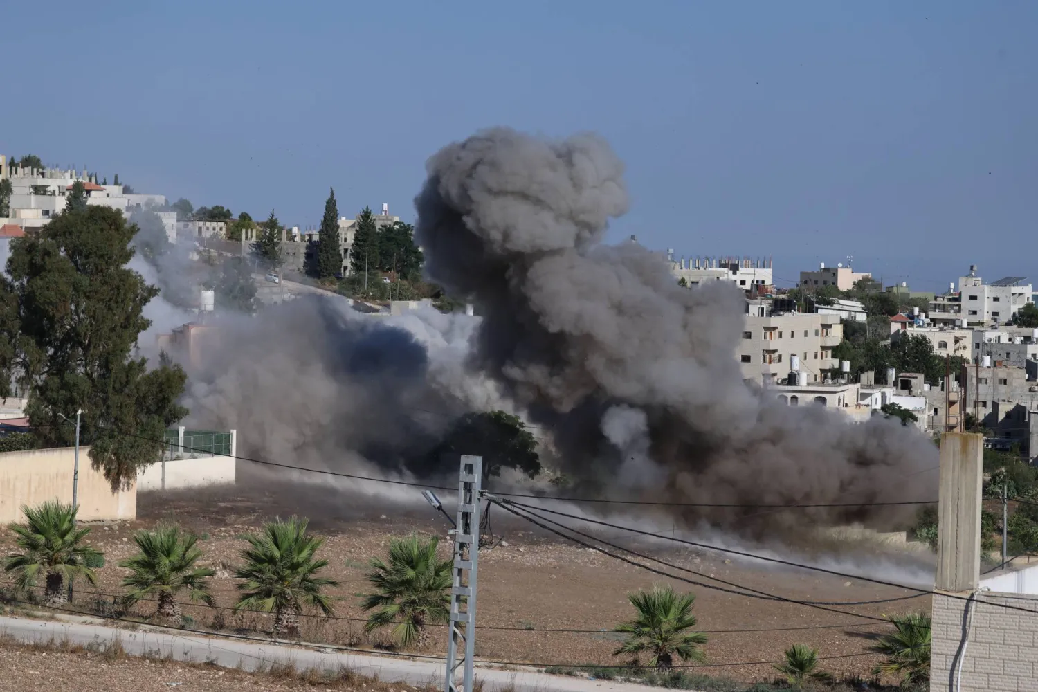Smoke rises as the Israeli army detonates explosives in the house of slain Palestinian Farouq Ramadan in Tell village, near the West Bank city of Nablus, 11 August 2026. (EPA)
