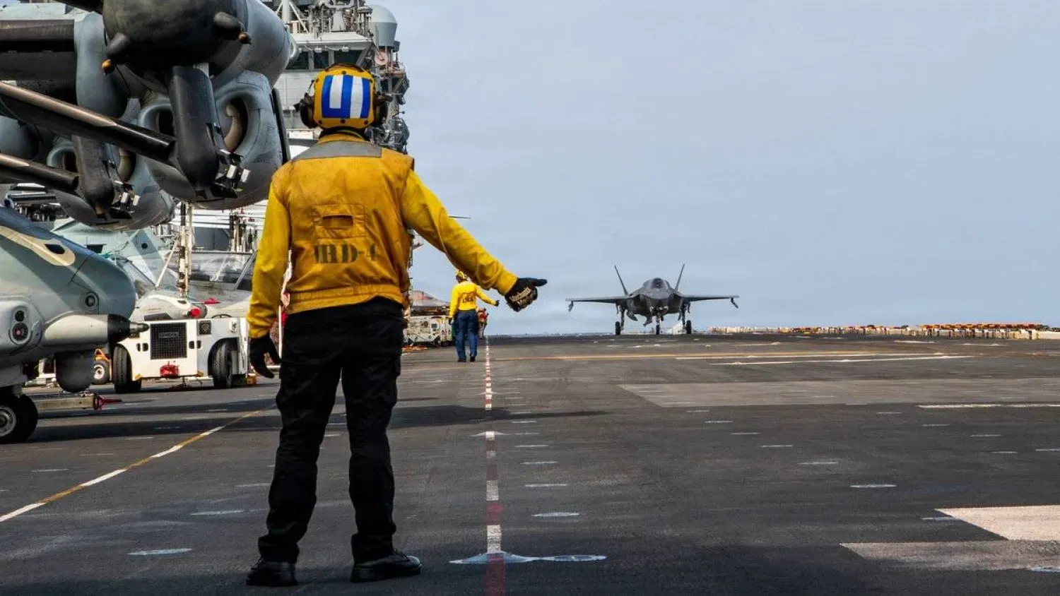 Amfibi saldırı gemisi USS Boxer'da görevli ABD’li bir denizci, bir F-35B savaş uçağına yol gösterirken (CENTCOM)