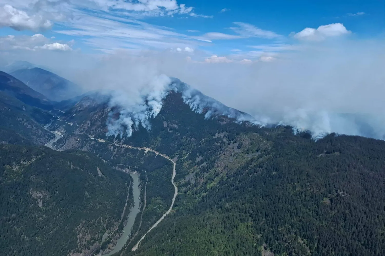 Smoke rises from the Brunswick Creek wildfire, looking north over the Fraser River near Boston Bar, British Columbia, Canada, August 11, 2026 in an aerial photograph. (BC Wildfire/Handout via Reuters)