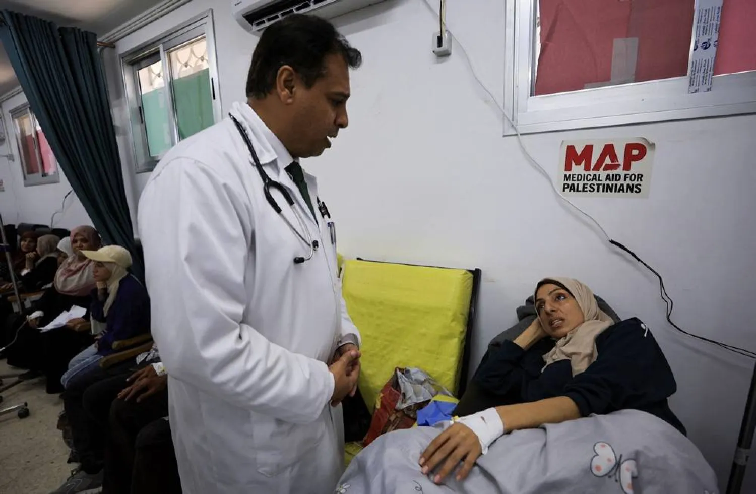 Palestinian cancer patient Elham Al-Sakafi, 38, speaks to a doctor after receiving nutritional intravenous fluids at Al-Shifa Hospital in Gaza City, August 6, 2026, according to medics. (Reuters)