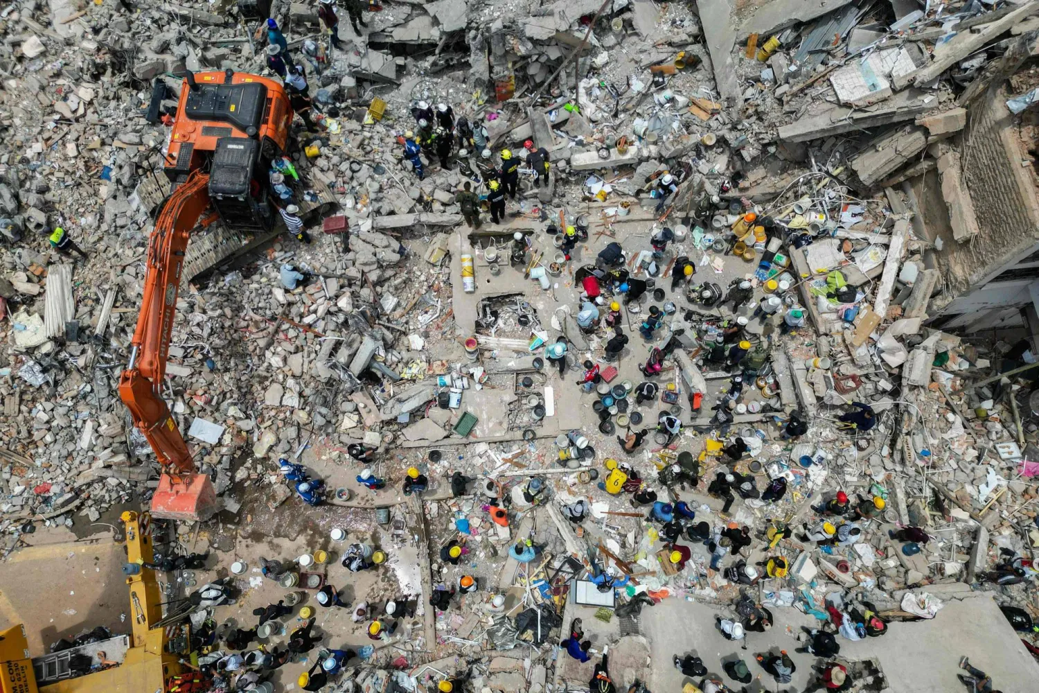 This aerial view shows heavy machinery used by rescuers in the search for survivors amid the rubble of a collapsed building after an earthquake in Pereira, Colombia on August 12, 2026. (AFP)