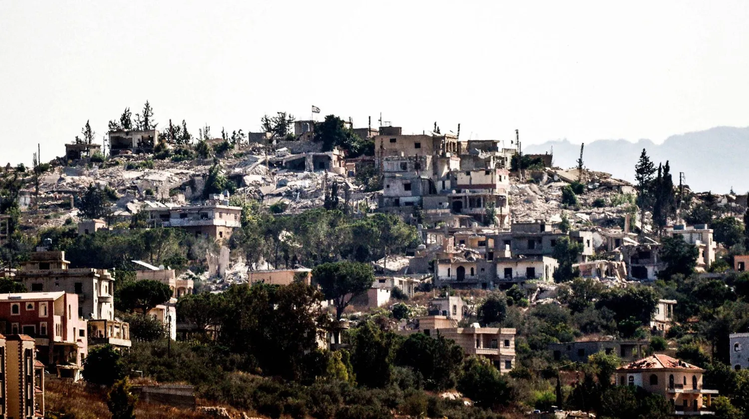  عَلم إسرائيلي مرفوع على مبانٍ مدمرة في بلدة حولا المحتلة جنوب لبنان (أ.ف.ب)