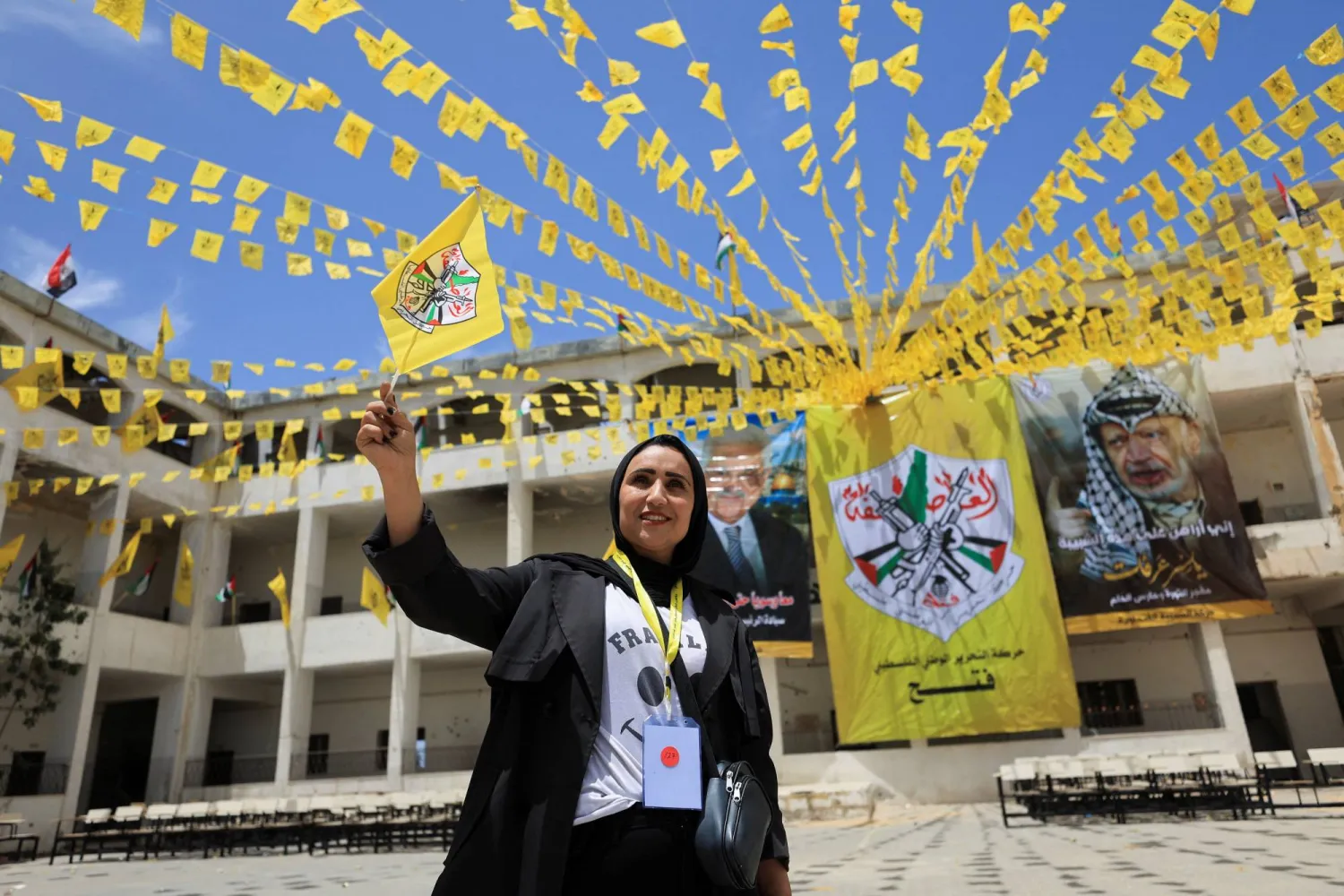 فلسطينية تلوّح بعَلم «فتح» خلال مشاركتها بالمؤتمر الثامن للحركة في جامعة الأزهر بمدينة غزة 14 مايو 2026 (رويترز)