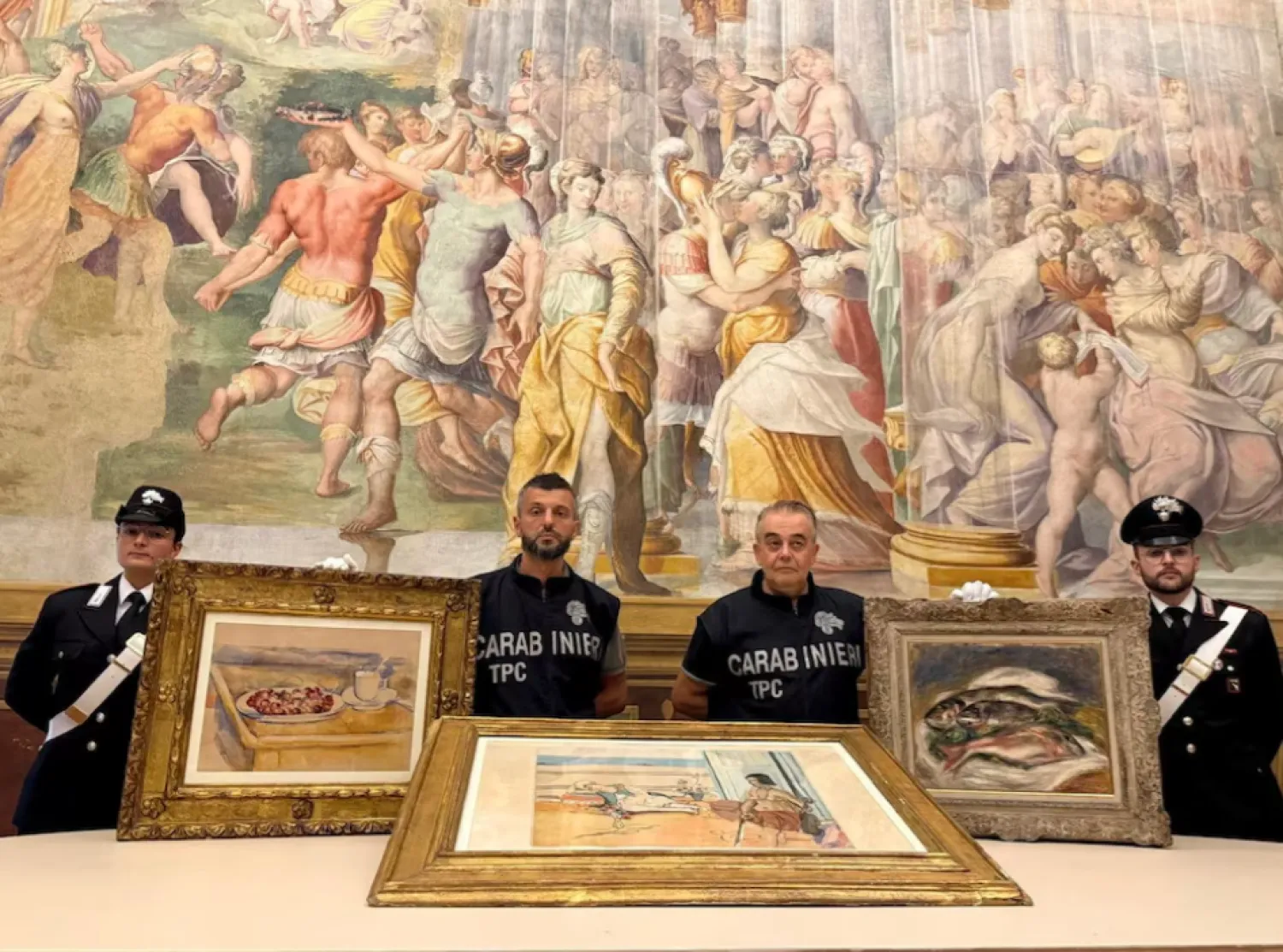 Carabinieri officers pose with three paintings by Paul Cezanne, Henri Matisse and Pierre-Auguste Renoir recovered after they were stolen from the Magnani Rocca Foundation in Mamiano, Italy, in this handout image released on August 14, 2026. Carabinieri/Handout via REUTERS 