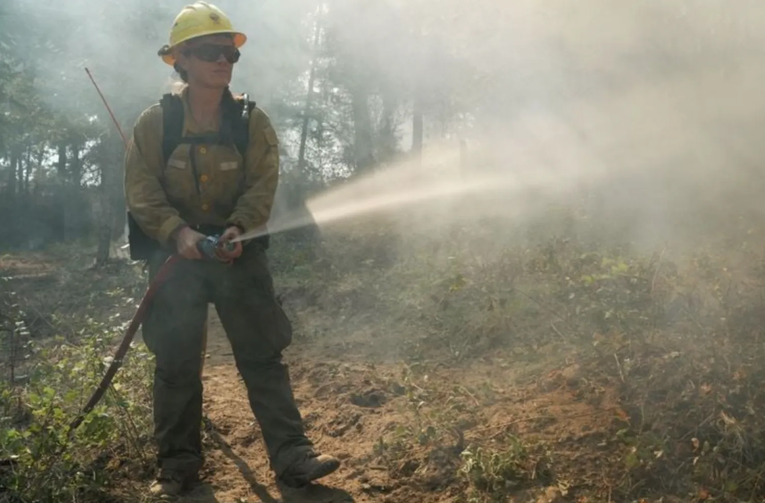 Washington state Department of Natural Resources South Puget Sound region firefighter Kayla Tolbert assists in wildfire suppression efforts in Spokane County, Washington, U.S., August 5, 2026. REUTERS