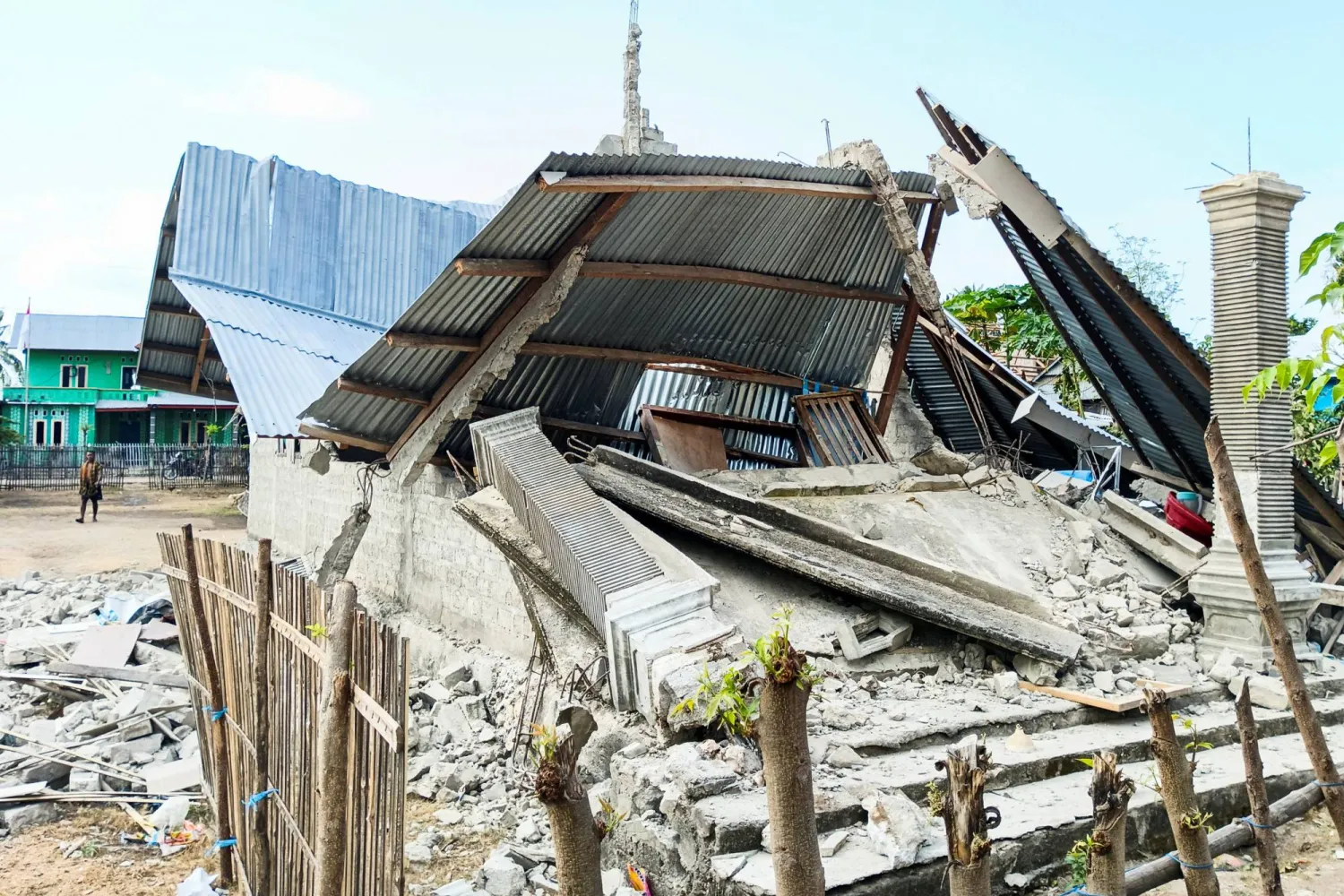 A person walks near a heavily-damaged house after an earthquake felt in Nanga Mbaur village, East Manggarai, East Nusa Tenggara province, Indonesia, August 16, 2026. (Reuters)