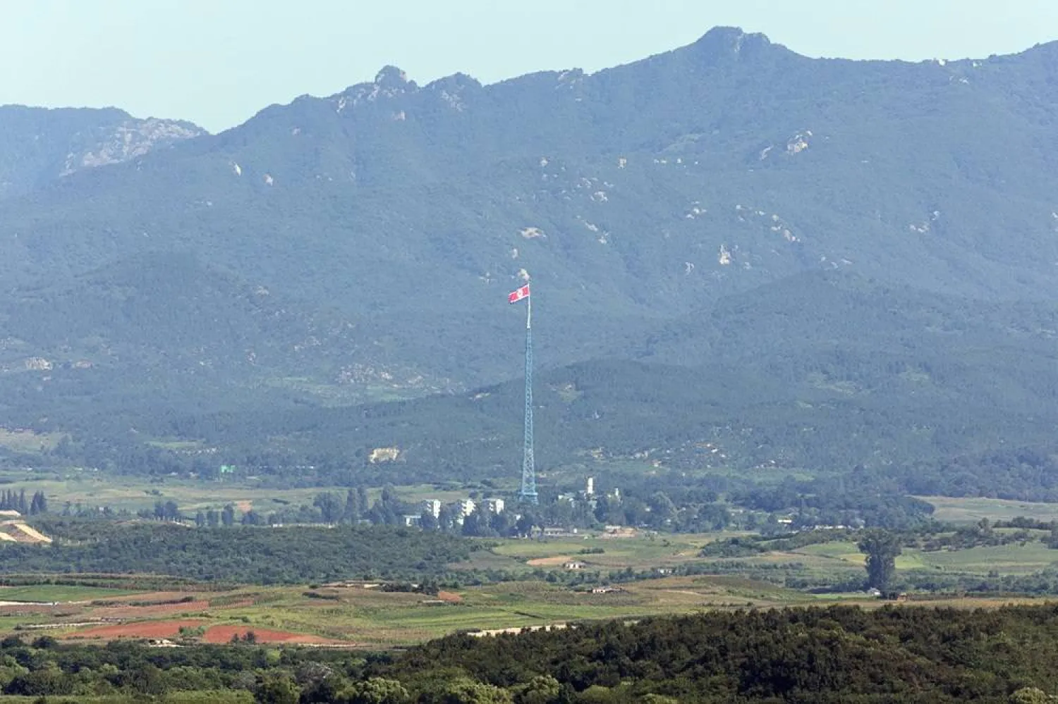 A North Korean flag flies in the North's Kijong Village on the western border with South Korea, as seen from from an observatory in Paju, South Korea, 12 August 2026. (EPA/Yonhap)