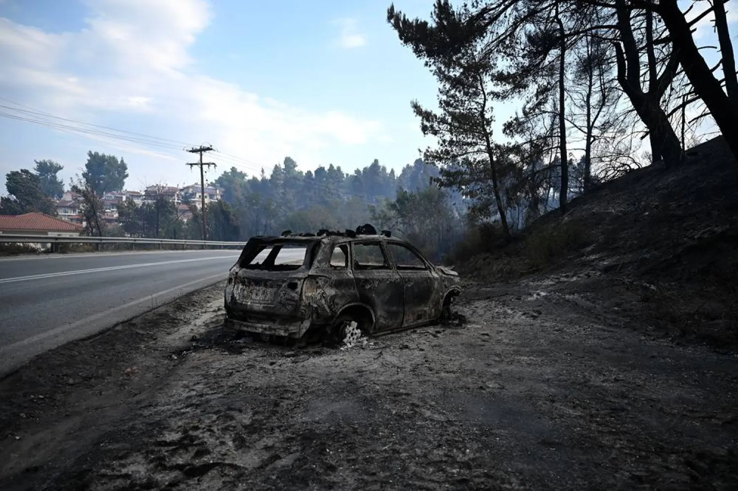 A burnt vehicle after a fire that broke out in the summer resort of Siviri, Chalkidiki, northern Greece, 14 August 2026. (EPA) 