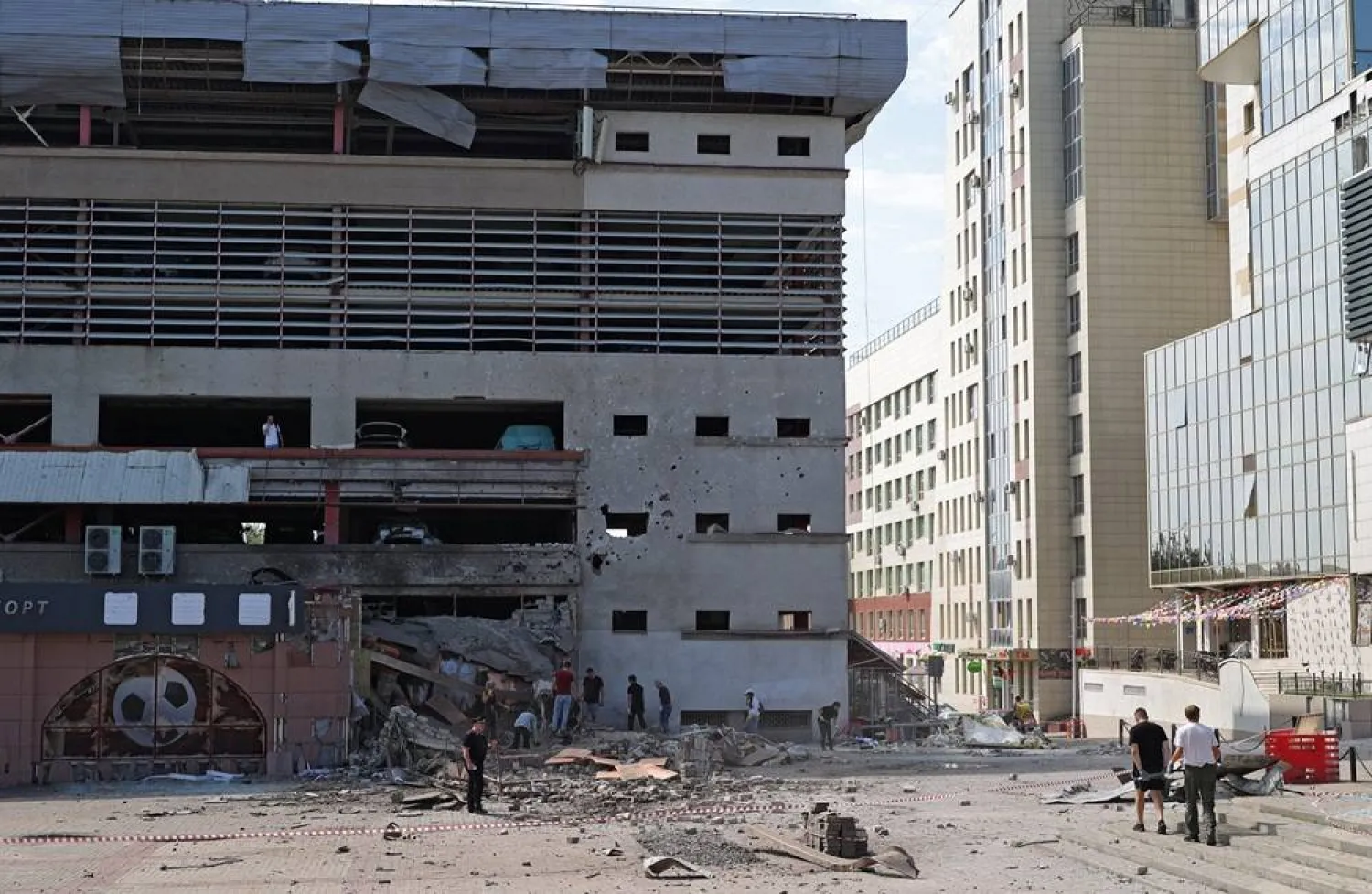 People clean up debris outside a building damaged during a Ukrainian overnight drone attack, according to local authorities, in the course of Russia-Ukraine conflict, in central Belgorod, Russia August 9, 2026. (Reuters) 