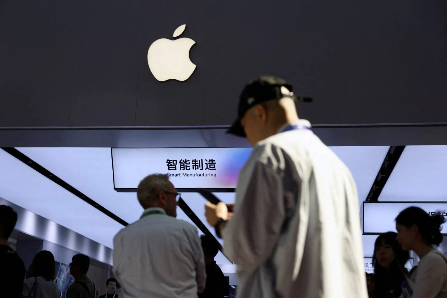 FILE PHOTO: People walk past a booth showcasing Apple's suppliers during the China International Supply Chain Expo (CISCE) in Beijing, China June 22, 2026. REUTERS/Florence Lo/File Photo