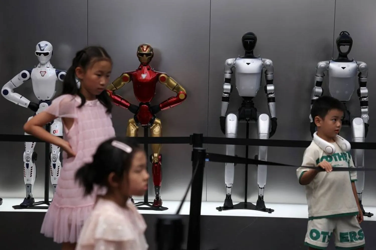 Children stand near Unitree's humanoid robots on display at a Unitree store in Beijing, China August 10, 2026. (Reuters)