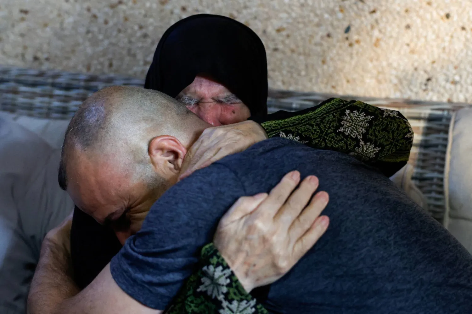  Palestinian-American Louis Ridi, who seeks access to his home in the Israeli-occupied West Bank that has been encircled by militant settlers for more than a week, embraces his mother at her home, in Qusra village, Israeli-occupied West Bank, August 17, 2026. (Reuters)