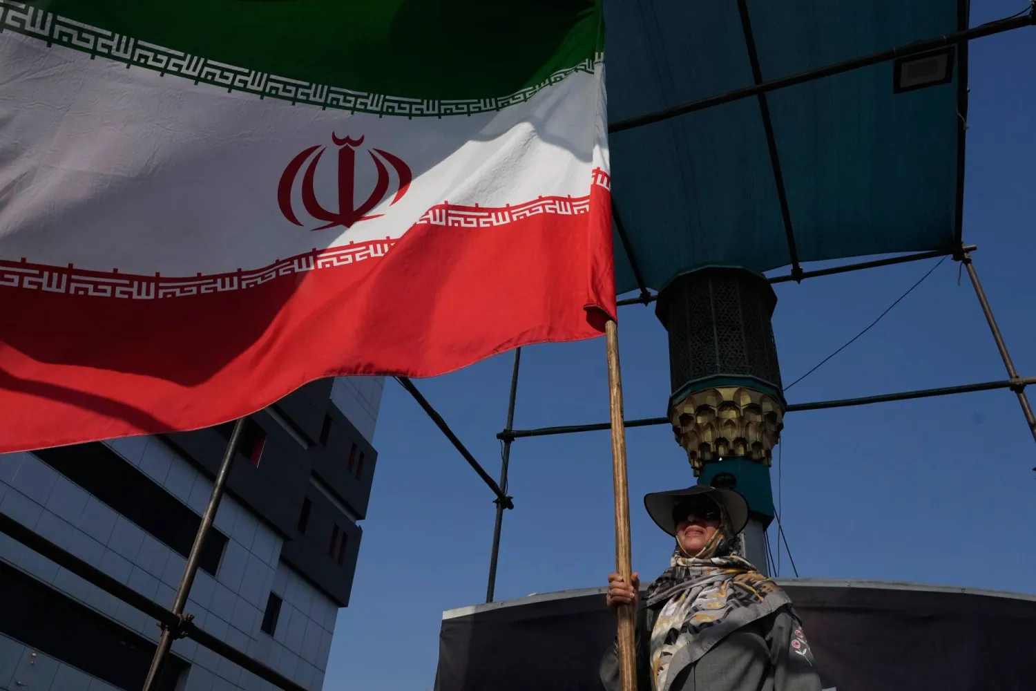 A woman holds an Iranian flag as part of a pro-government campaign in downtown Tehran, Iran, Monday, Aug. 17, 2026. (AP Photo/Vahid Salemi)
