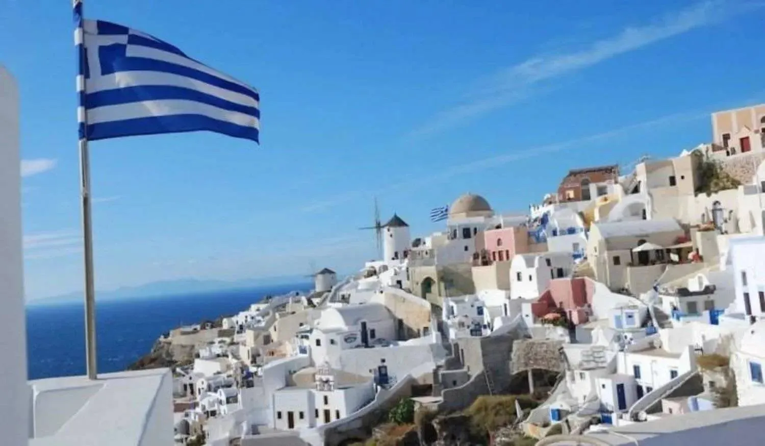 علم اليونان يرفرف على مدينة ساحلية قرب أثينا (رويترز)