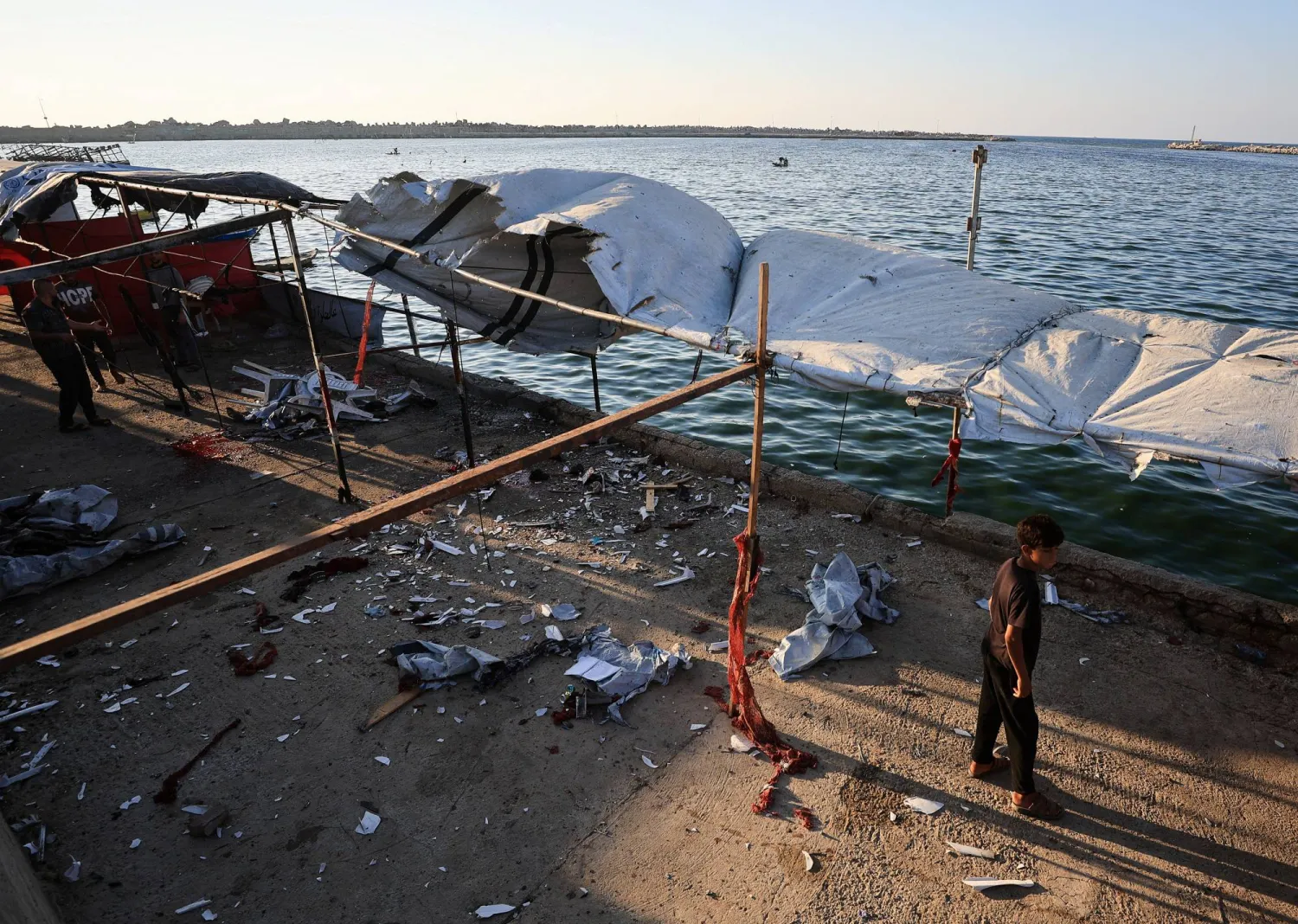 A Palestinian inspects the site of an Israeli strike on a cafe, at the seaport of Gaza City, August 18, 2026. (Reuters)