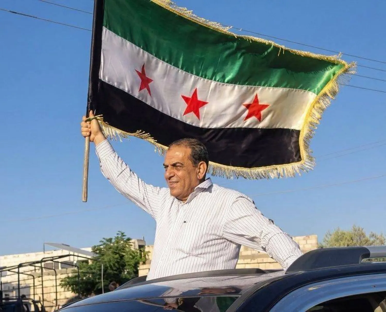 مصعب أبو ركبة لدى وصوله إلى نوى بمحافظة درعا رافعاً العلم السوري الذي لم ينجه من الاعتقال