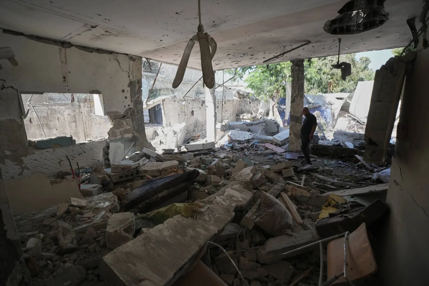 فلسطينيون يتفقدون الأضرار في مركز للشرطة بعد قصف إسرائيلي بمدينة غزة يوم الأربعاء (أ.ب)