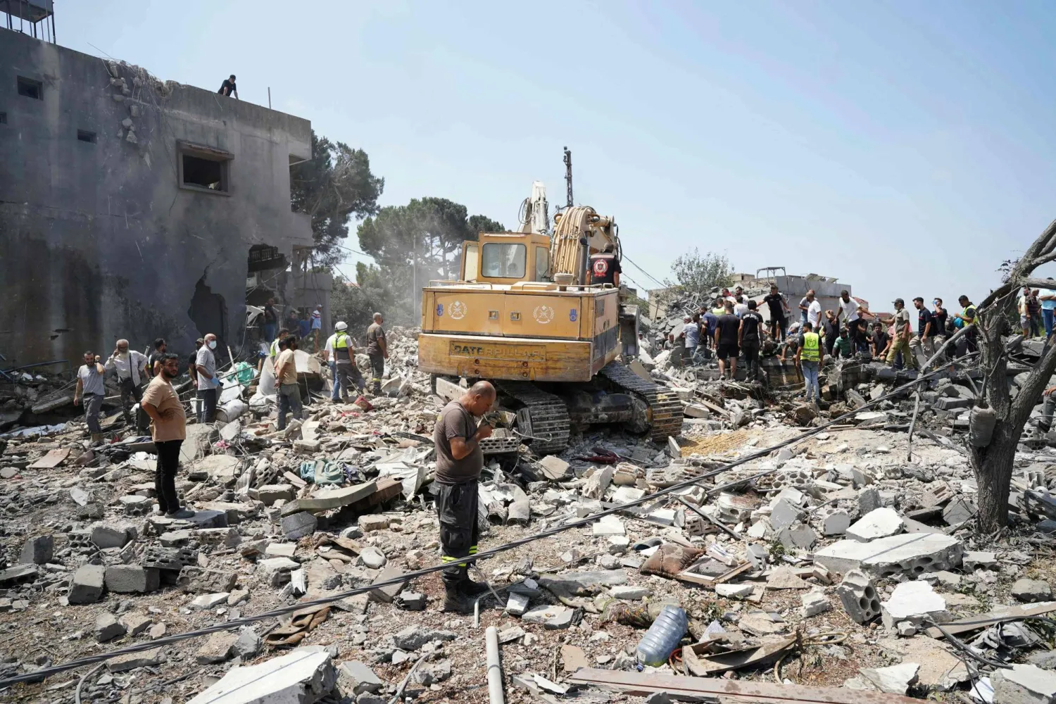 آليات وفرق إسعاف وسكان يفتشون موقع غارة جوية إسرائيلية استهدفت حياً في قرية دير الزهراني جنوب لبنان - 15 أغسطس 2026 (أ.ف.ب)