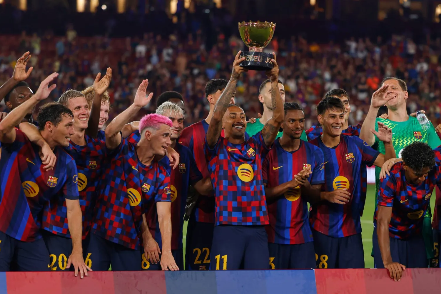 لاعبو برشلونة يحتفلون بالتتويج بكأس خوان غامبر عقب الفوز على الأهلي المصري في ملعب «كامب نو» (أ.ب)
