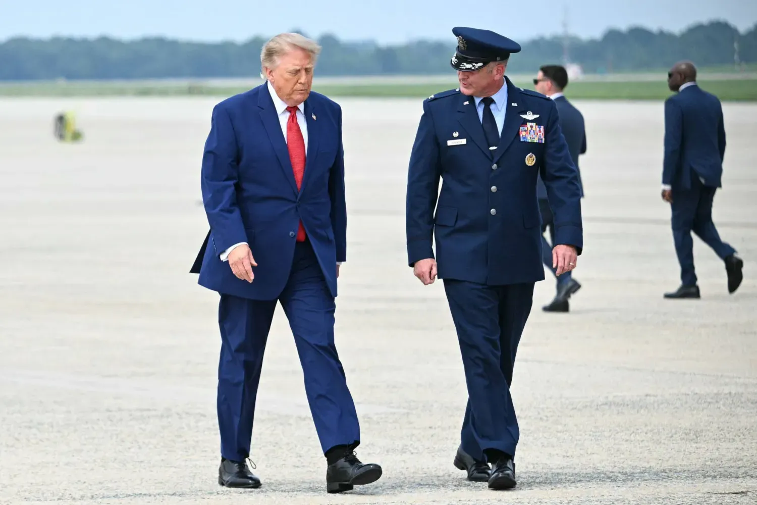 ABD Başkanı Donald Trump, Maryland eyaletindeki Andrews Müşterek Üssü'nde başkanlık uçağına binmek üzere ilerlerken 89. Hava İkmal Kanadı Komutanı Albay Christopher M. Robinson ile sohbet ediyor (AFP)