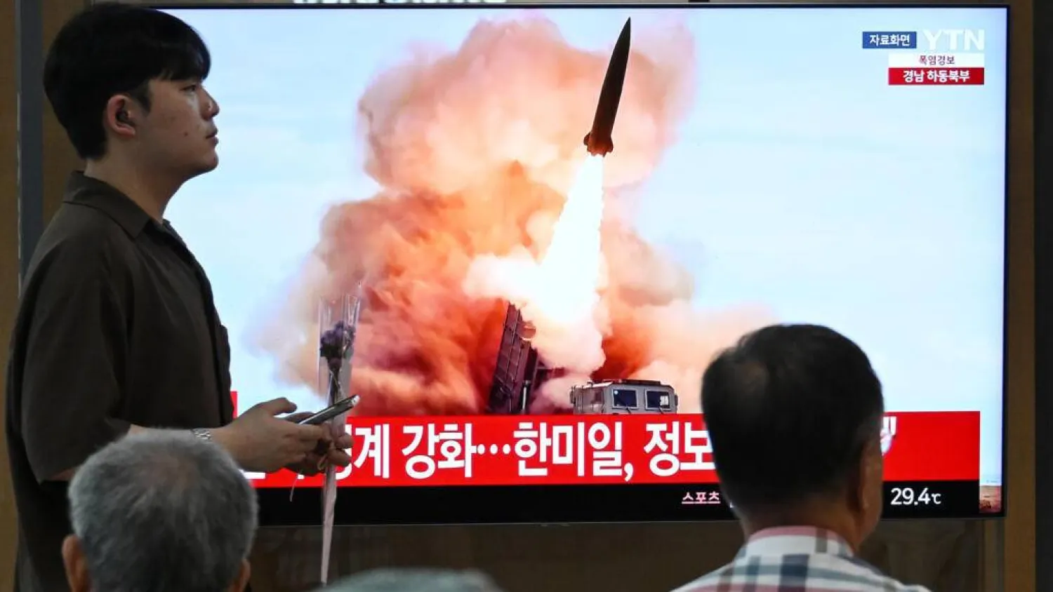 People watch a news broadcast with file footage of a North Korean missile test, at a train station in Seoul. Jung Yeon-je / AFP
