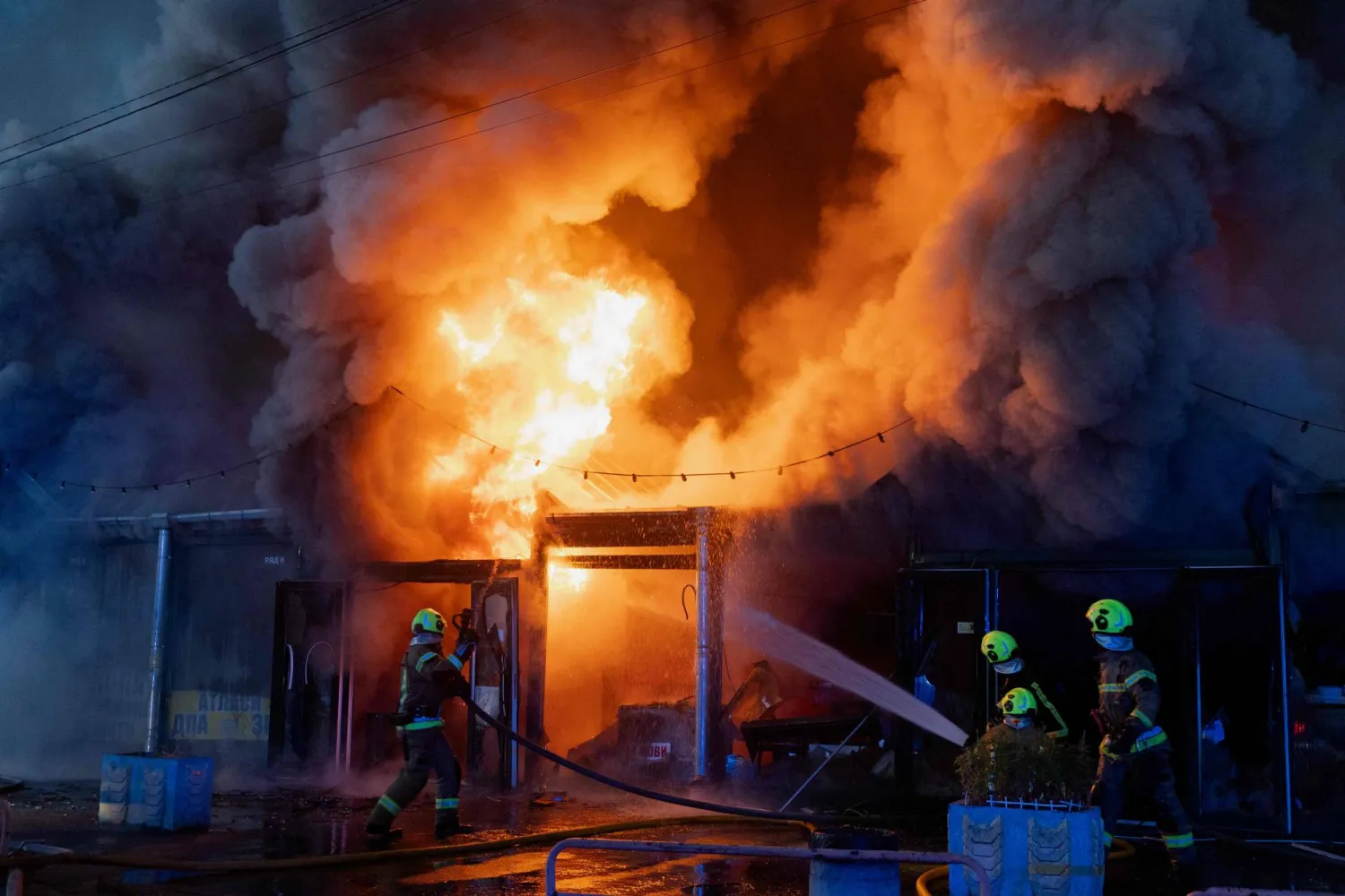 عمال إطفاء في موقع أُصيب بالقصف الروسي للعاصمة الأوكرانية (أ.ف.ب)