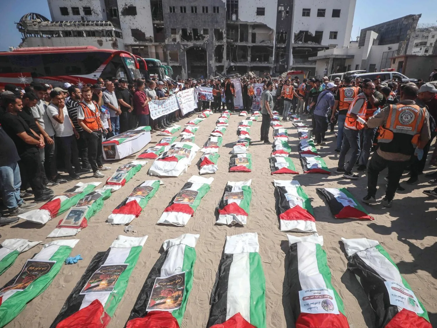 
مشيعون يلتفون حول رفات فلسطينيين قتلوا في ضربات خلال حرب غزة قبيل دفنهم بمدينة غزة أمس (أ.ف.ب)