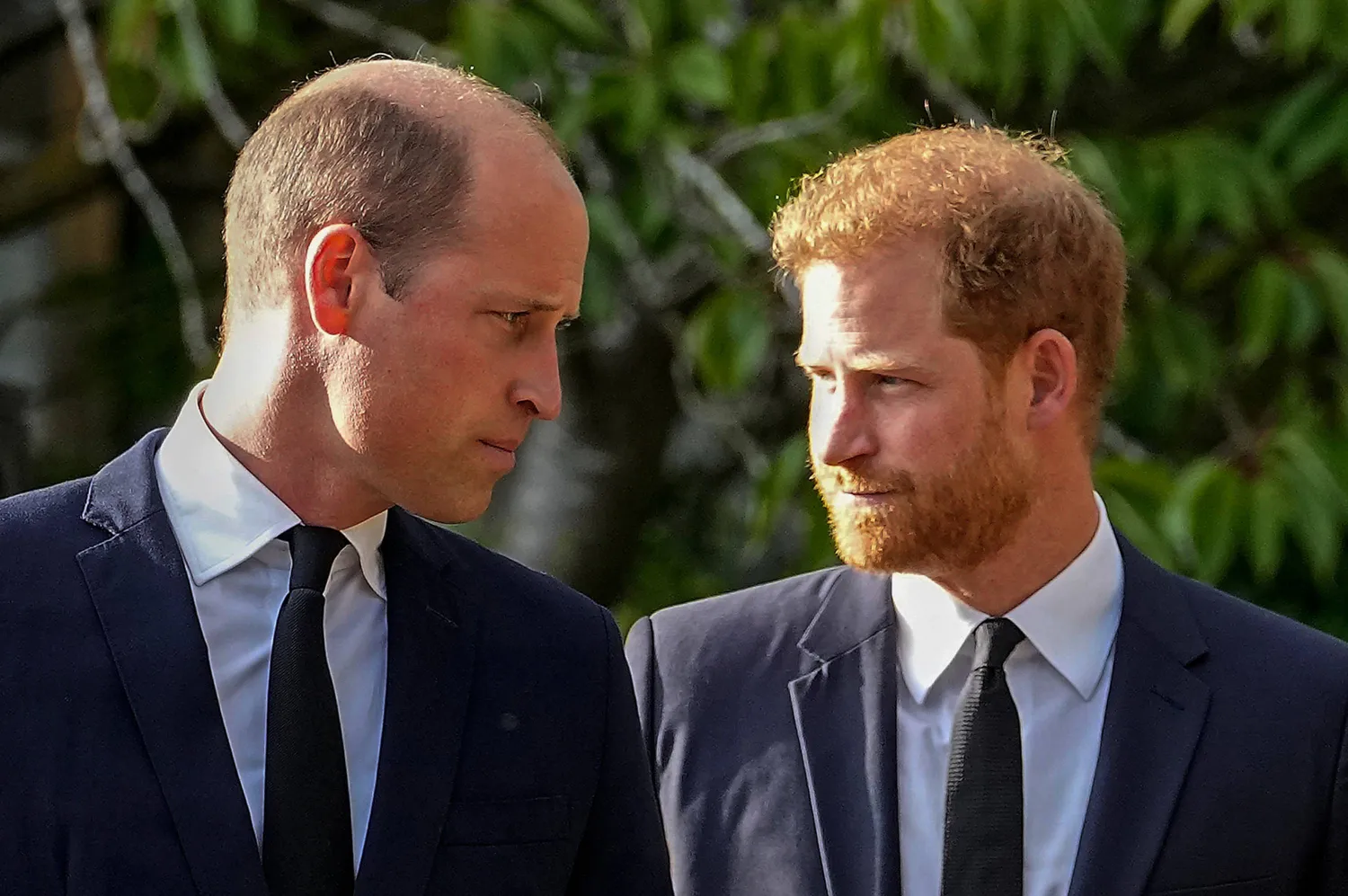 Britain's Prince William and Britain's Prince Harry walk beside each other after viewing the floral tributes for the late Queen Elizabeth II outside Windsor Castle, in Windsor, England on Sept. 10, 2022. (AP)