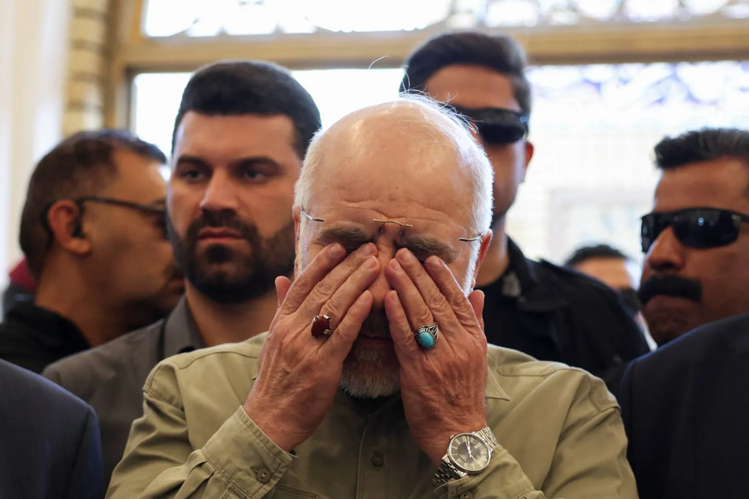 رئيس البرلمان الإيراني محمد باقر قاليباف باكياً في النجف العراقية يوم الجمعة عند قبر أبو مهدي المهندس الذي قُتل إلى جانب قاسم سليماني في غارة أميركية في يناير 2020 (رويترز)