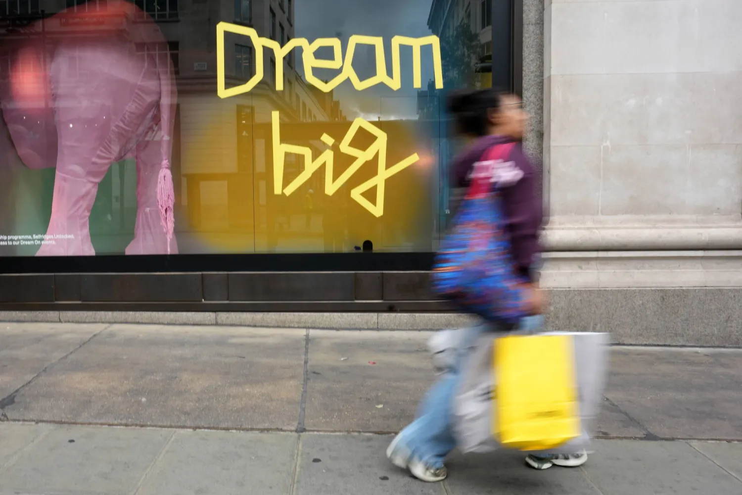 A shopper walks in Oxford Street, in London, Wednesday, Aug.19, 2026. (AP Photo/Kirsty Wigglesworth)