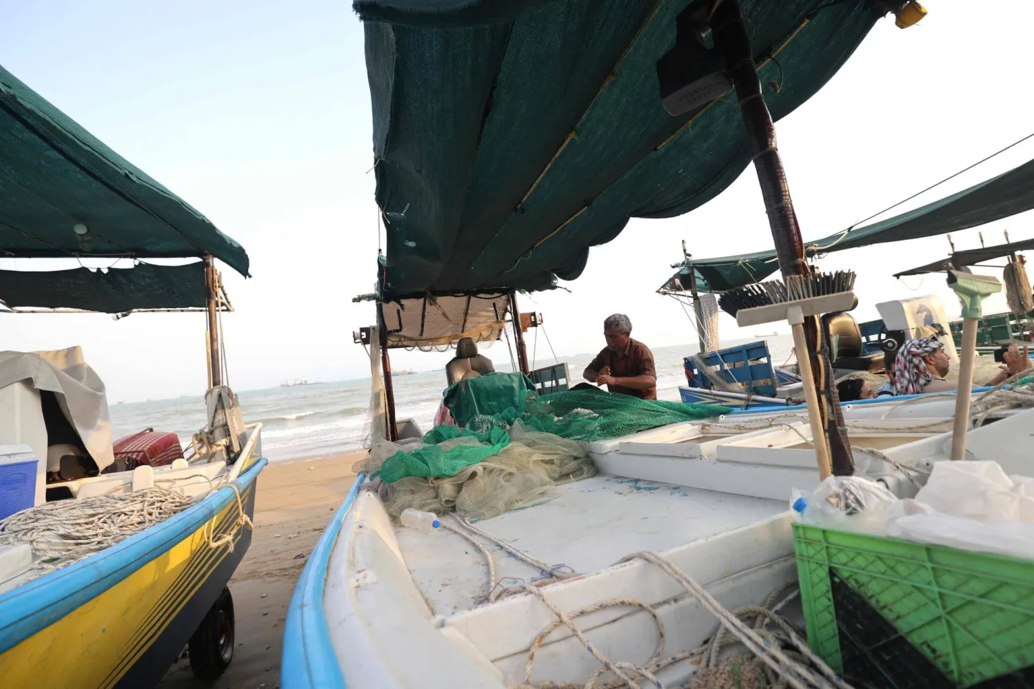 Fishermen check their nets and small boats on the seashore in the port city of Bandar Abbas, in southern Iran on August 10, 2026. (AFP)