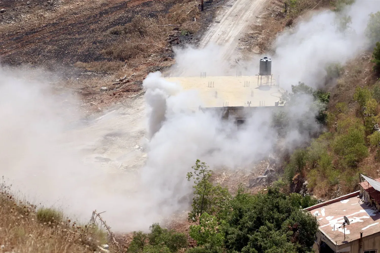 İsrail tanklarının Vadi es-Seluki bölgesindeki bir binayı bombalamasının ardından yükselen dumanlar... (Görüntü, Lübnan'ın güneyindeki Şakra köyünden alındı) (EPA)