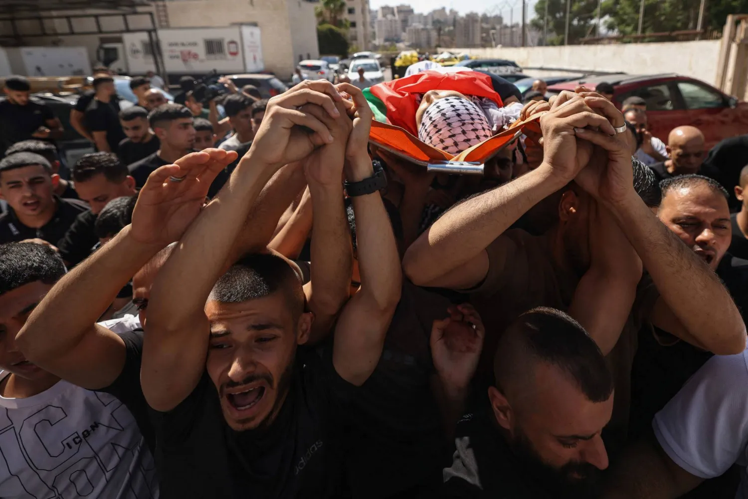 Mourners carry the body of Palestinian Islam Ajouri, 14, at Rafidia Hospital in Nablus in the Israeli-occupied West Bank, on August 23, 2026. (Photo by JAAFAR ASHTIYEH / AFP)