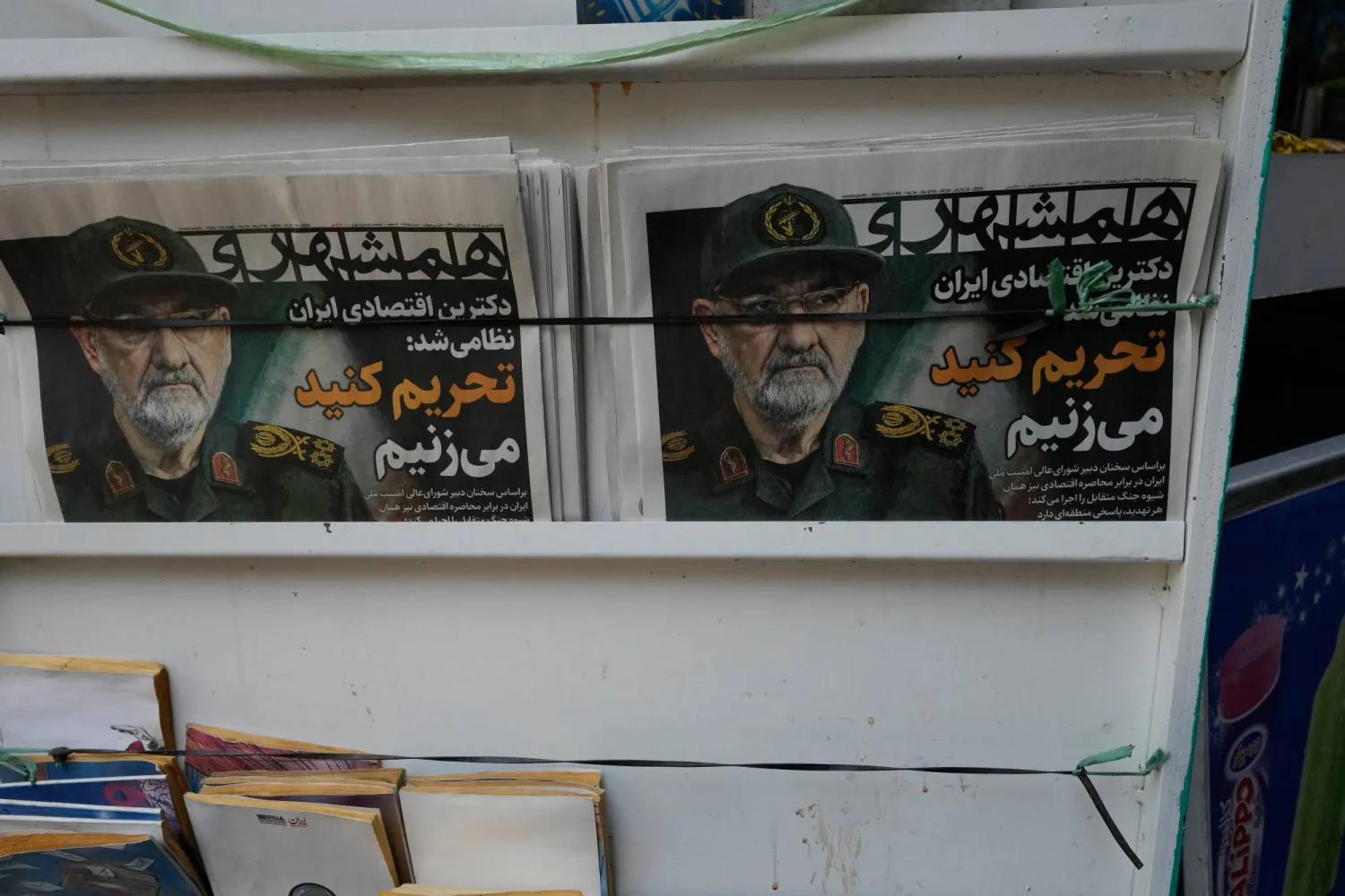 صحيفة «همشهري» الإيرانية معروضة في كشك بوسط طهران تحت عنوان «العقيدة الاقتصادية الإيرانية أصبحت عسكرية» وصورة أمين المجلس الأعلى للأمن القومي محسن رضائي... الاثنين 24 أغسطس 2026 (أ.ب)
