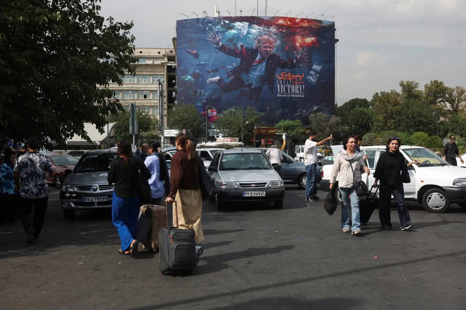(foto altı) Tahran’daki bir binada ABD Başkanı Donald Trump’ı gösteren propaganda afişinin önünden geçen insanlar, 22 Ağustos 2026 (Reuters)