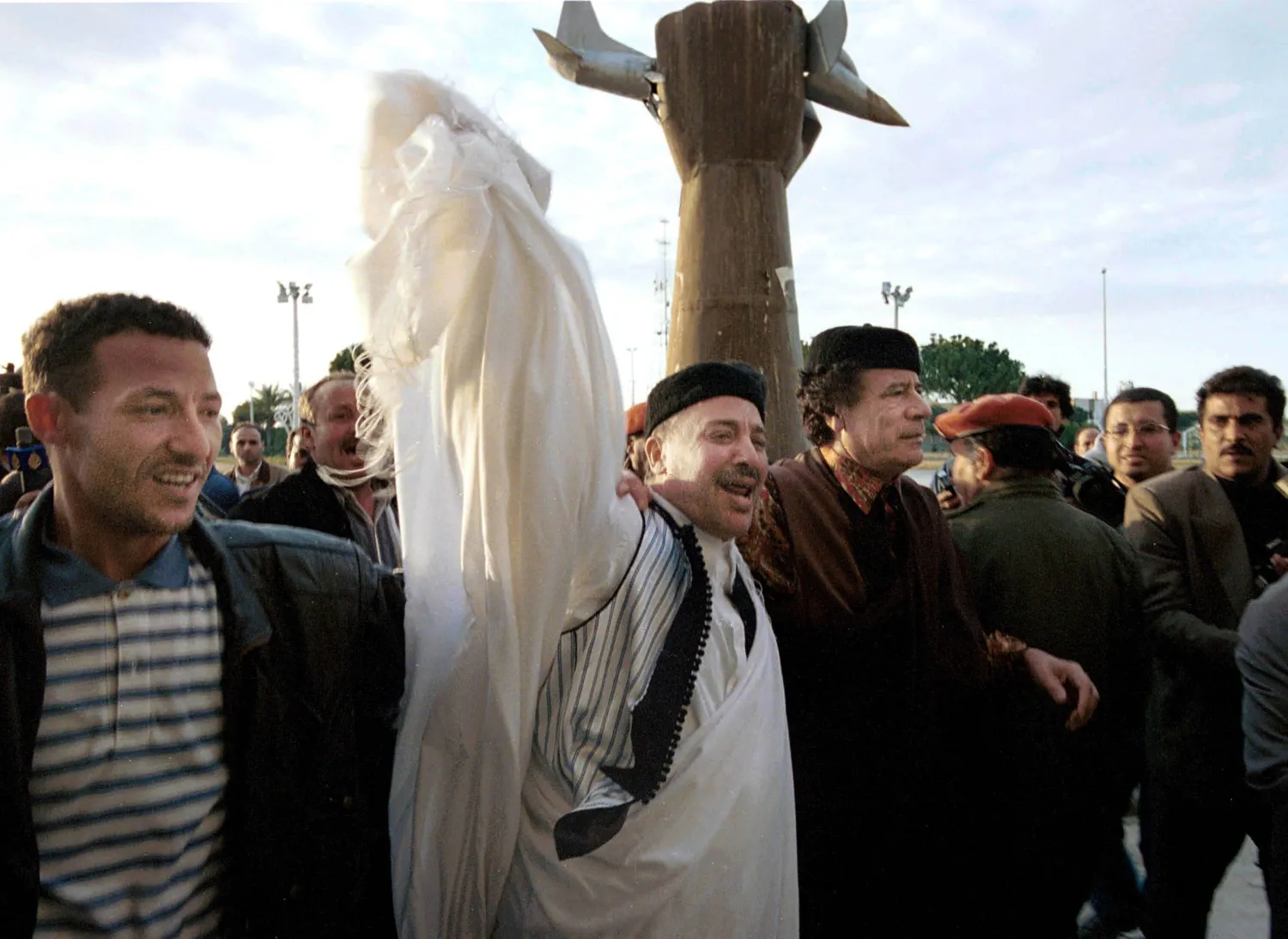 صورة تجمع الرئيس الليبي الراحل معمر القذافي، وإلى جواره (الثاني من اليسار) الأمين خليفة فحيمة، وذلك فور وصول الأخير إلى العاصمة طرابلس غداة تبرئته قطعيّاً من قضية تفجير الطائرة (طرابلس 1 فبراير 2001) (غيتي)
