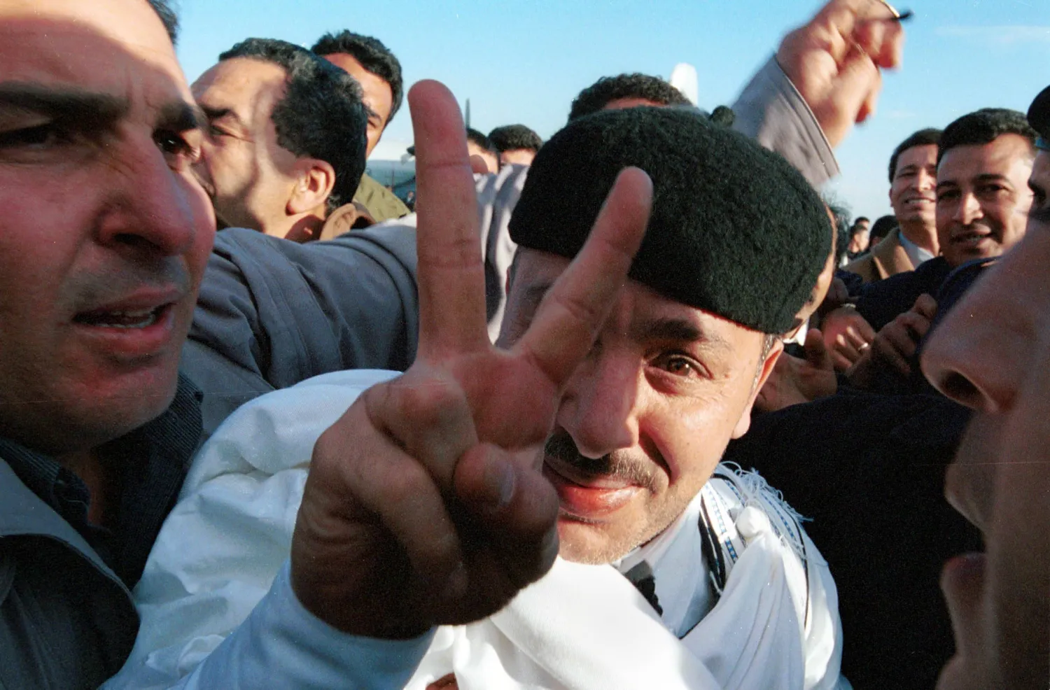 الأمين خليفة فحيمة مُلوّحاً بيده بعد يوم واحد من تبرئته في محاكمة تفجير لوكربي (غيتي)