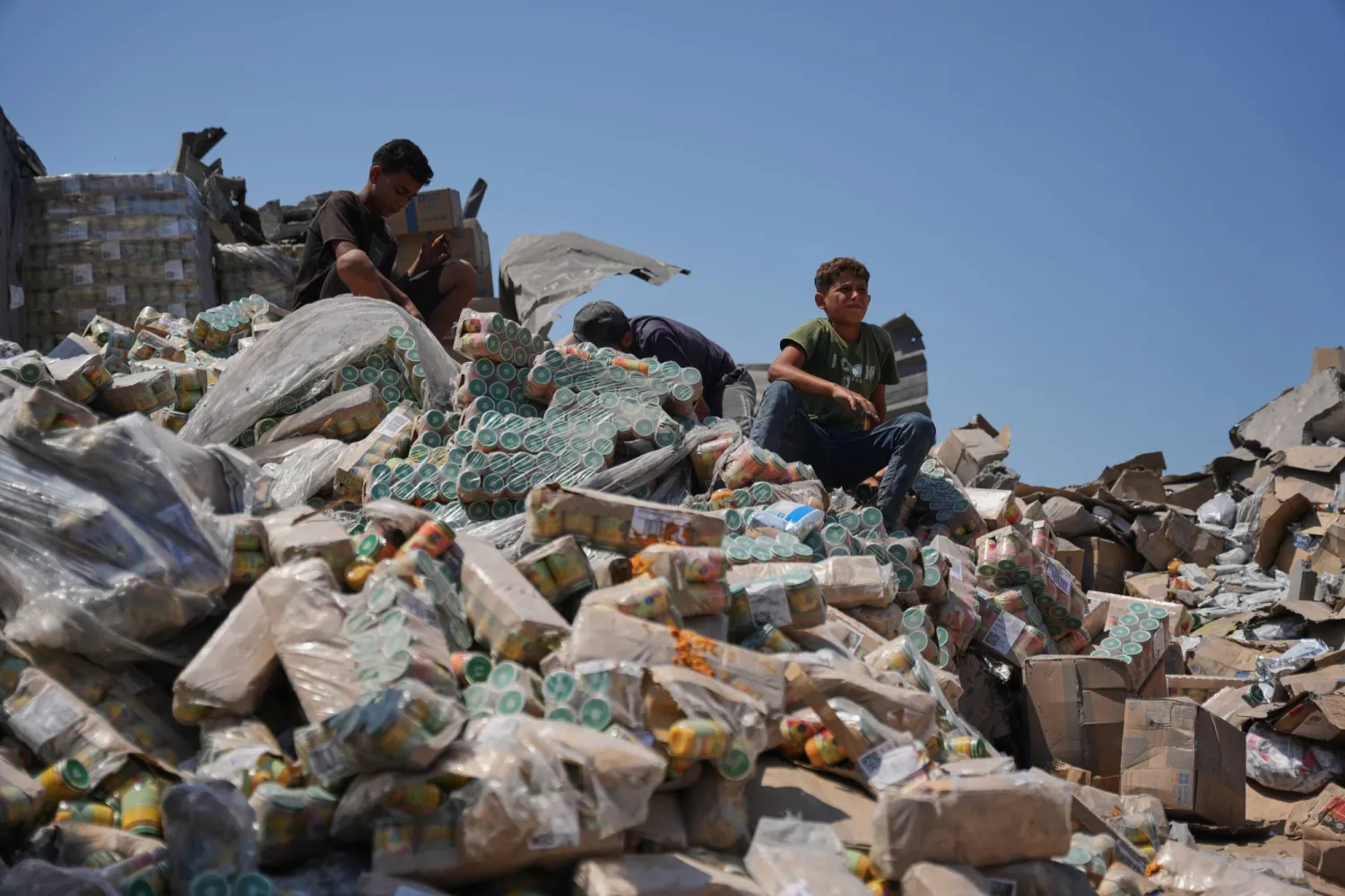 فلسطينيون في مستودع للمساعدات الغذائية تضرر من غارة إسرائيلية استهدفت منزلاً مجاوراً في دير البلح وسط غزة الأربعاء (أ.ب)