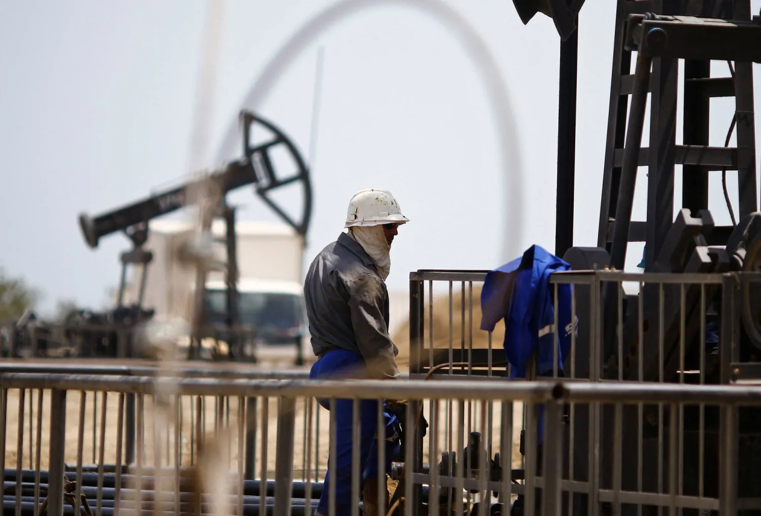 A worker rests next to an oil pump on a sunny day in Baku, Azerbaijan, June 16 , 2015. (Reuters)