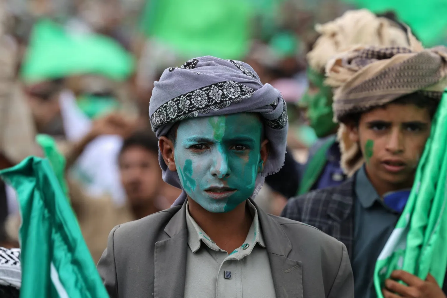 صبي ملطخ وجهه بالألوان يشارك في حشد للحوثيين بصنعاء (رويترز)