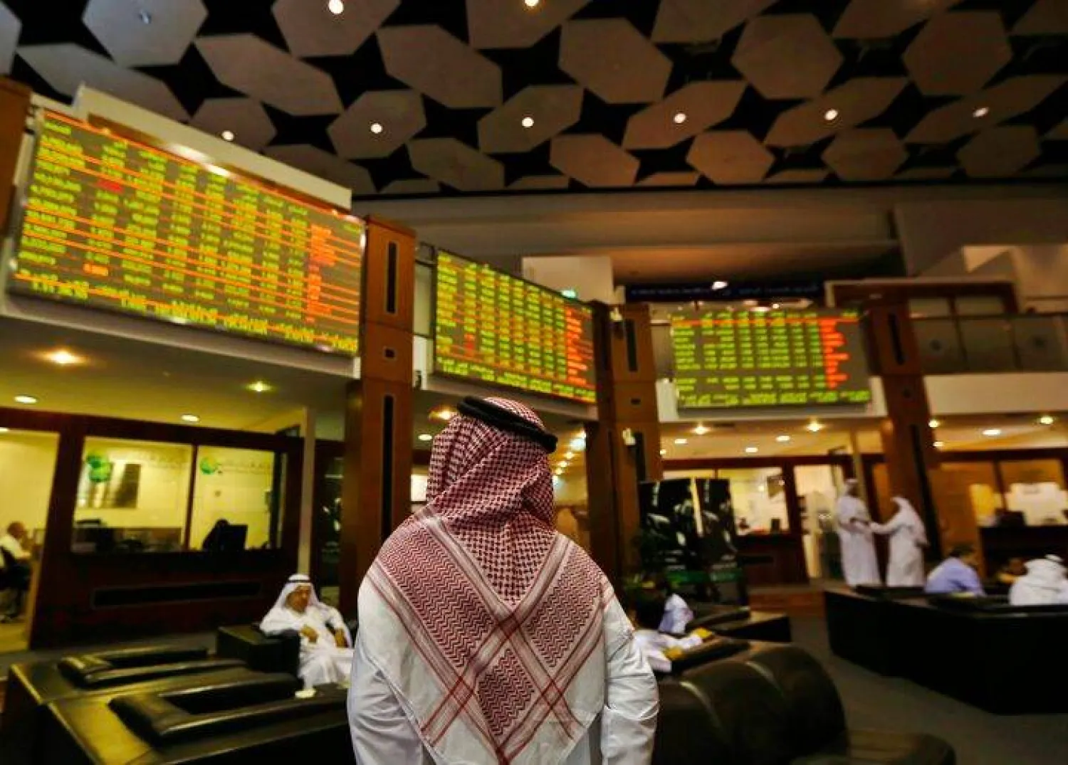 مستثمر يتابع الأسهم في سوق دبي (رويترز)